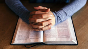 Prayer hands over bible